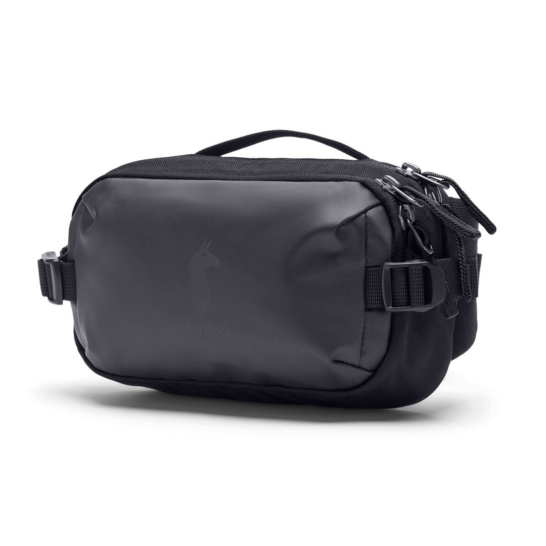 Allpa X 3L Hip Pack by Cotopaxi, compact black bag with multiple zippers and llama logo, ideal for essentials.