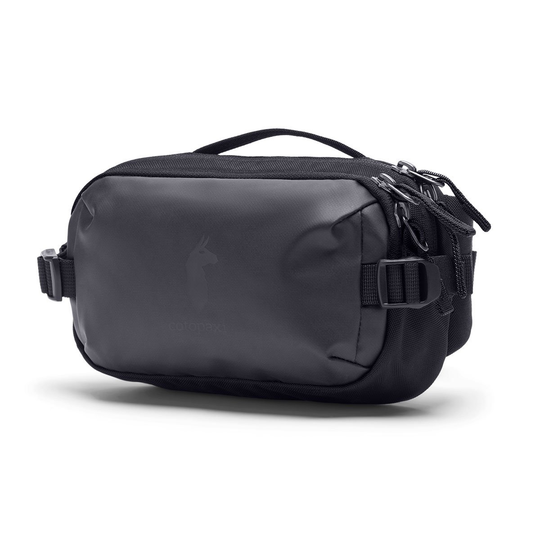 Allpa X 3L Hip Pack by Cotopaxi, compact black bag with multiple zippers and llama logo, ideal for essentials.