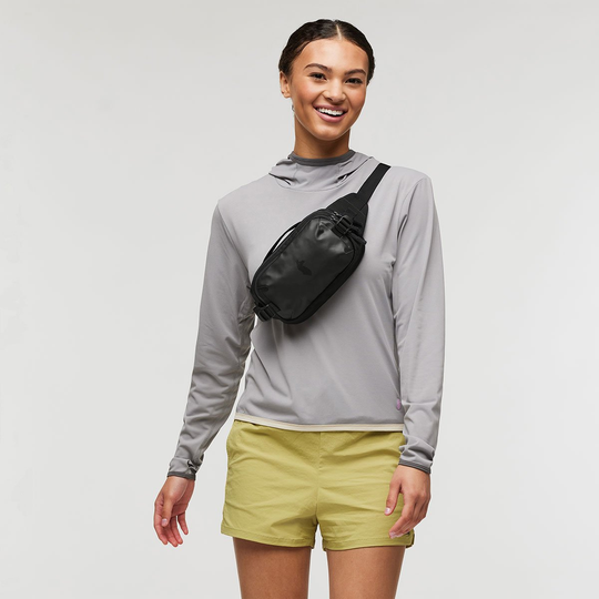 Allpa X 1.5L Hip Pack worn crossbody on a person, showcasing its compact design and versatility for travel.