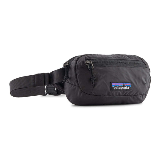 Terravia Mini Hip Pack in black, lightweight and water-repellent hip pack with adjustable strap and zippered compartments.