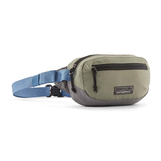 Terravia Mini Hip Pack in recycled nylon, compact and water repellent, with adjustable blue strap and zippered compartments.