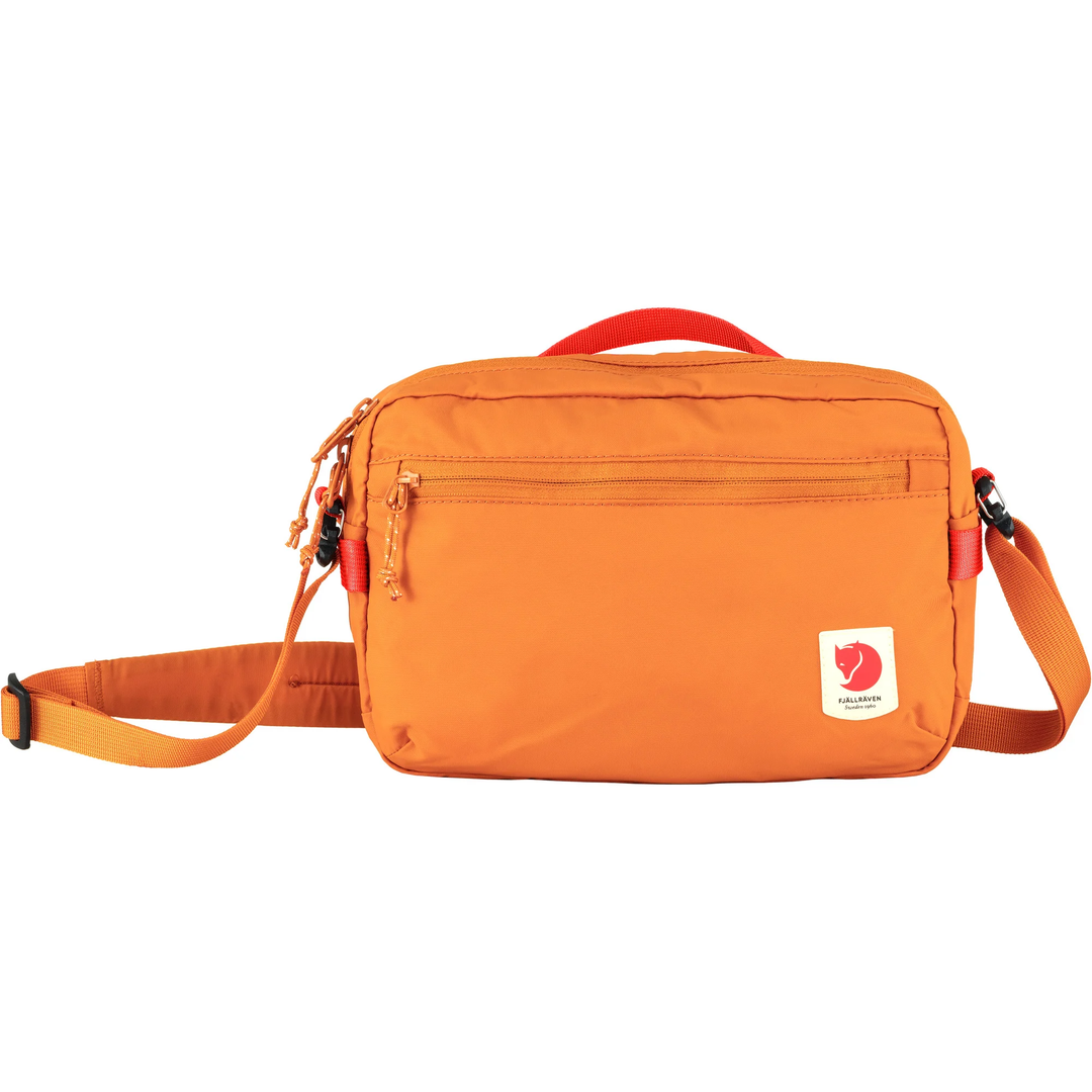 High Coast Crossbody in orange with adjustable strap, front zipper pocket, and recycled polyamide material.