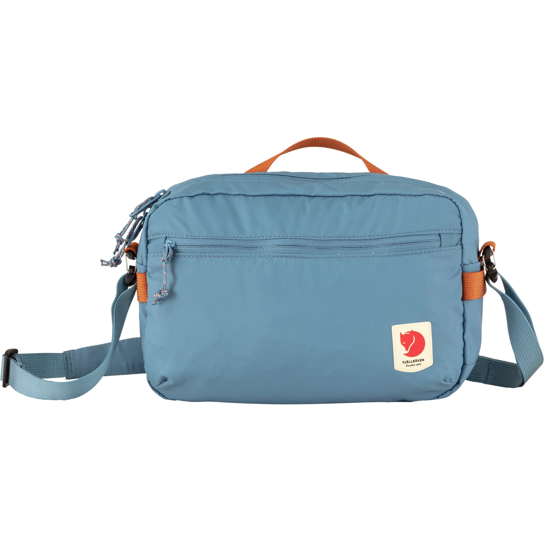 High Coast Crossbody bag in blue with adjustable strap and multiple pockets.