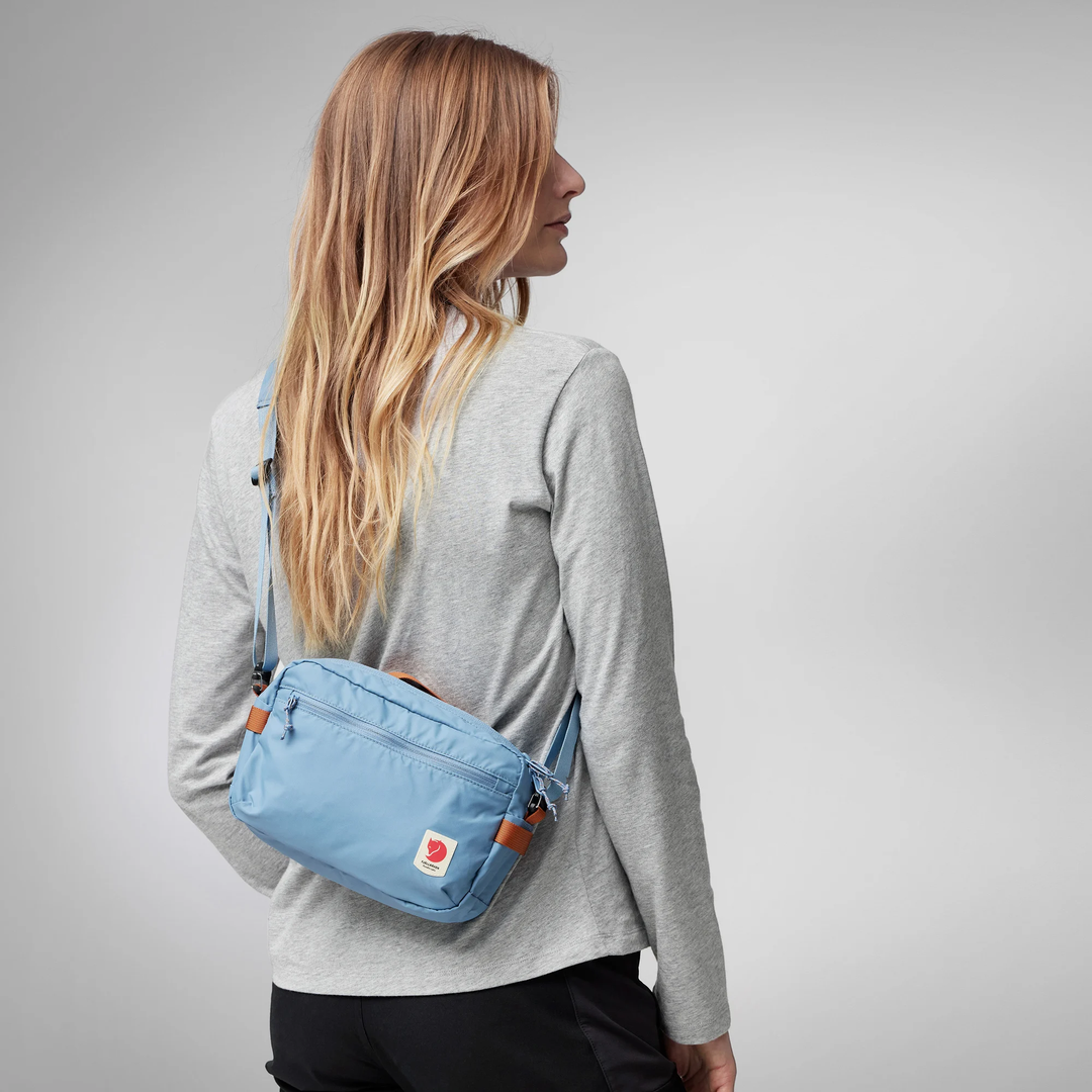 High Coast Crossbody bag in blue, lightweight and functional design for travel and city use, adjustable strap.
