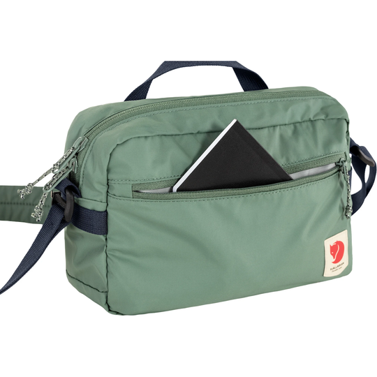 High Coast Crossbody bag in green with front zip pocket and adjustable strap.