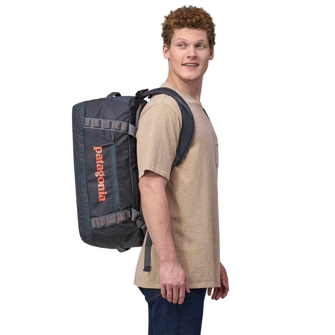 Man carrying Black Hole Duffel 40L as a backpack, showcasing ergonomic straps and compact design.
