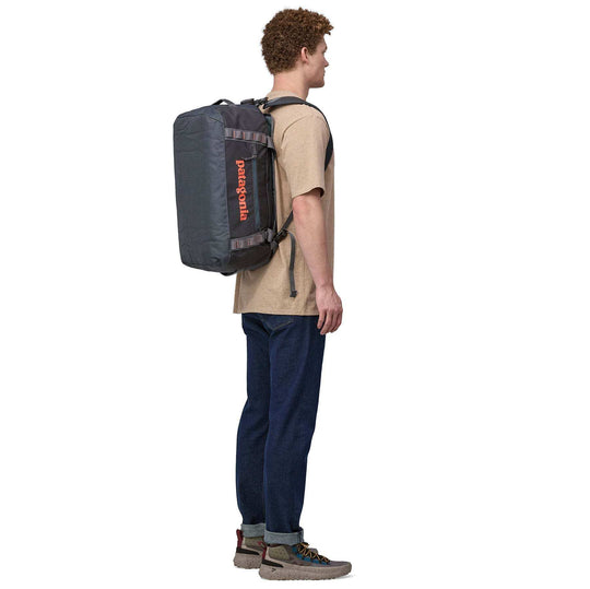 Black Hole Duffel 40L backpack worn by a person, showcasing versatile carrying straps.