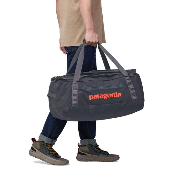 Black Hole Duffel 55L in use, ergonomic straps, durable recycled fabric.
