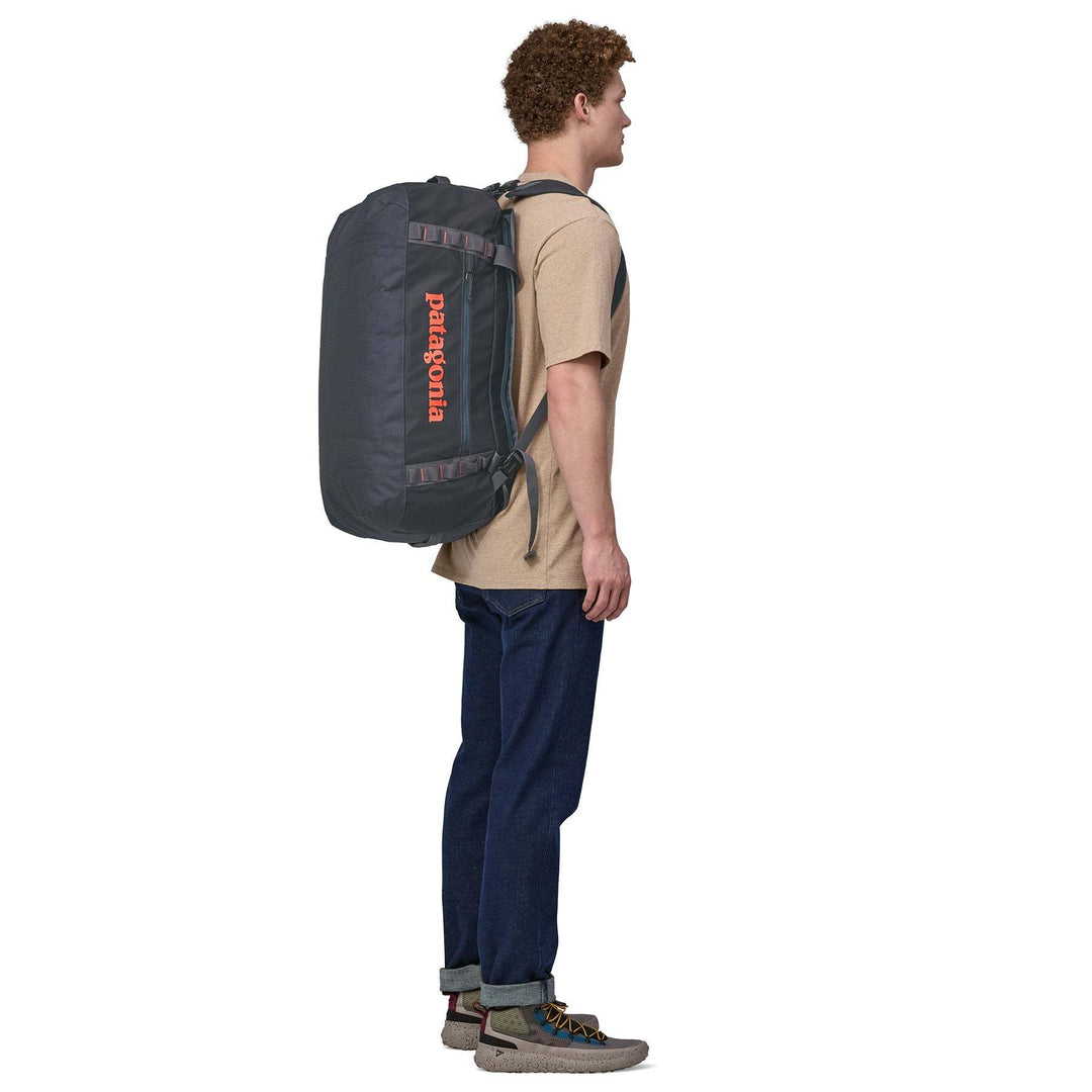 Person wearing Black Hole Duffel 55L as a backpack with ergonomic removable straps.