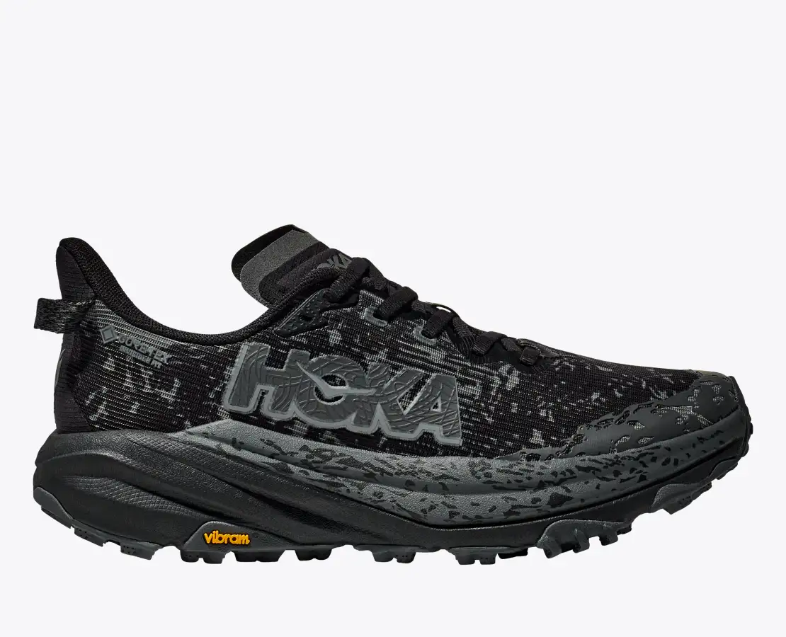 Trail running shoe Hoka W Speedgoat 6 GTX, black, featuring waterproof GORE-TEX, Vibram Megagrip sole, and flexible design.
