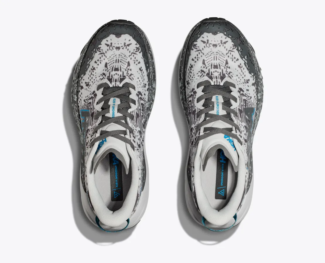 Trail running shoes with a grey and white pattern, featuring GORE-TEX and Vibram Megagrip soles.