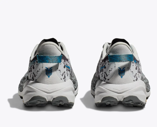Trail running shoes, Speedgoat 6 GTX, featuring GORE-TEX Invisible Fit, Vibram Megagrip outsole, and reinforced heel in white and blue.