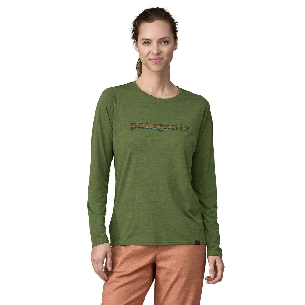 Woman wearing the green "W's L/S Cap Cool Daily Graphic Shirt" with moisture-wicking and odor control technology, made from recycled polyester.