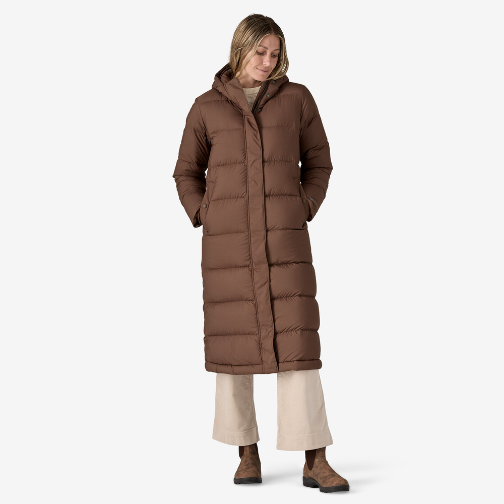 Long brown parka with hood and knee-length design, featuring bi-directional zip and handwarmer pockets.