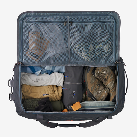 Black Hole Duffel 70L open with organized gear and clothing inside, showcasing spacious and accessible main compartment.