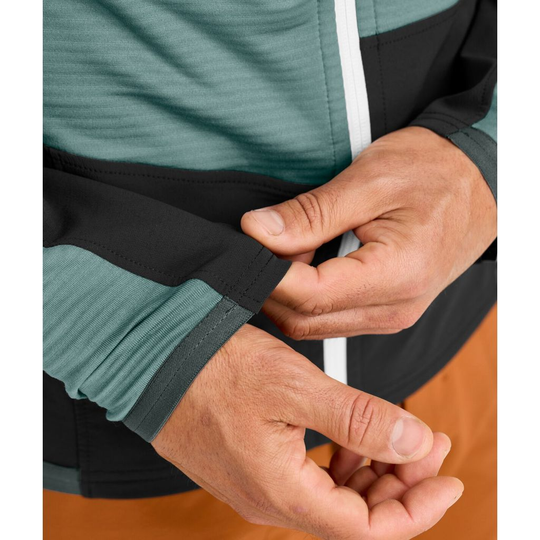Close-up of hands adjusting sleeve on a men's fleece rib jacket, showcasing durable material and double zipper.