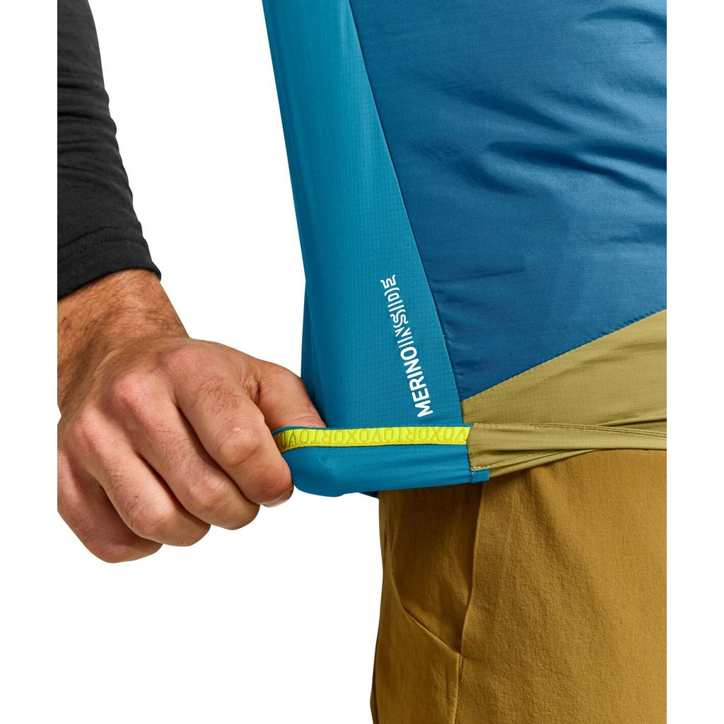 Lightweight windbreaker vest for alpine use, featuring Merino wool and Tec-Stretch materials for breathability, wind resistance, and water repellency.