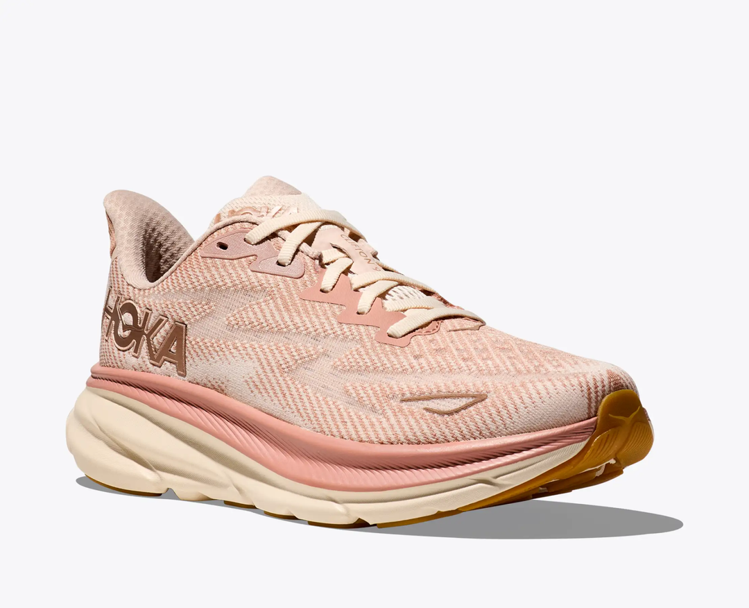 Clifton 9 running shoe in pink and beige with lightweight design and cushioned sole.