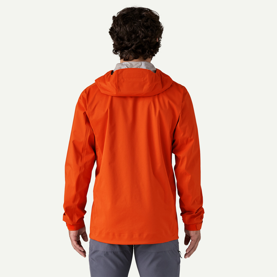 Back view of orange M's M10 Storm Jkt with adjustable hood and sleek design for alpine activities.