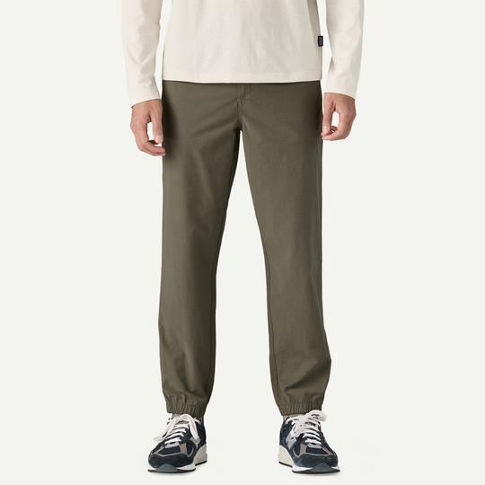 M's Nomader Joggers, comfortable and durable joggers, made from organic cotton, recycled polyester, and elastane, shown in green color, perfect for travel.