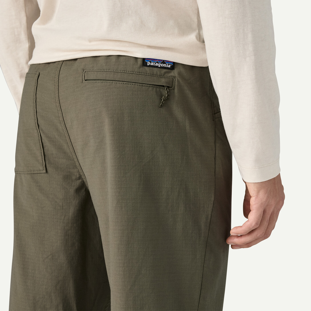 M's Nomader Joggers in green, showcasing durable, stretch fabric with rear zippered pocket detail.