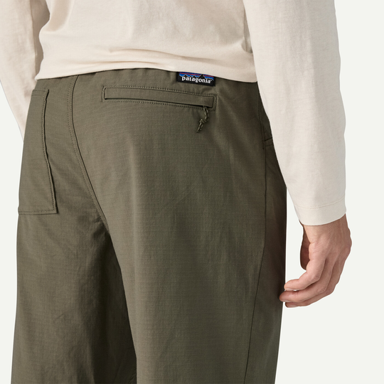 M's Nomader Joggers in green, showcasing durable, stretch fabric with rear zippered pocket detail.