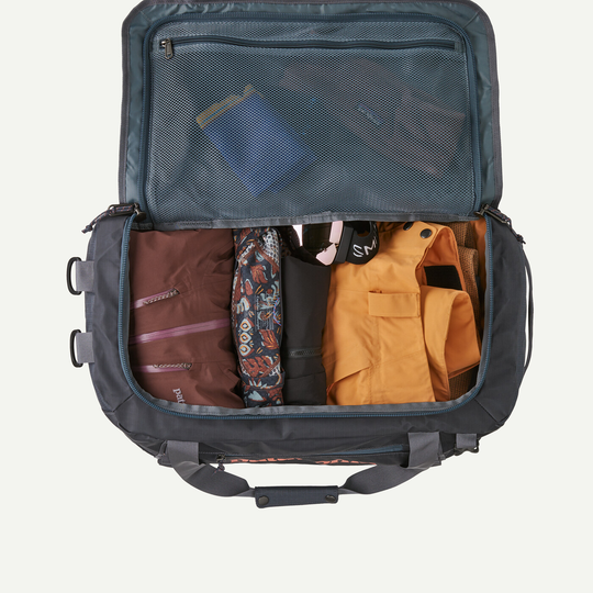 40L Black Hole Duffel with open main compartment showing organized interior, mesh pocket, and packed clothing.