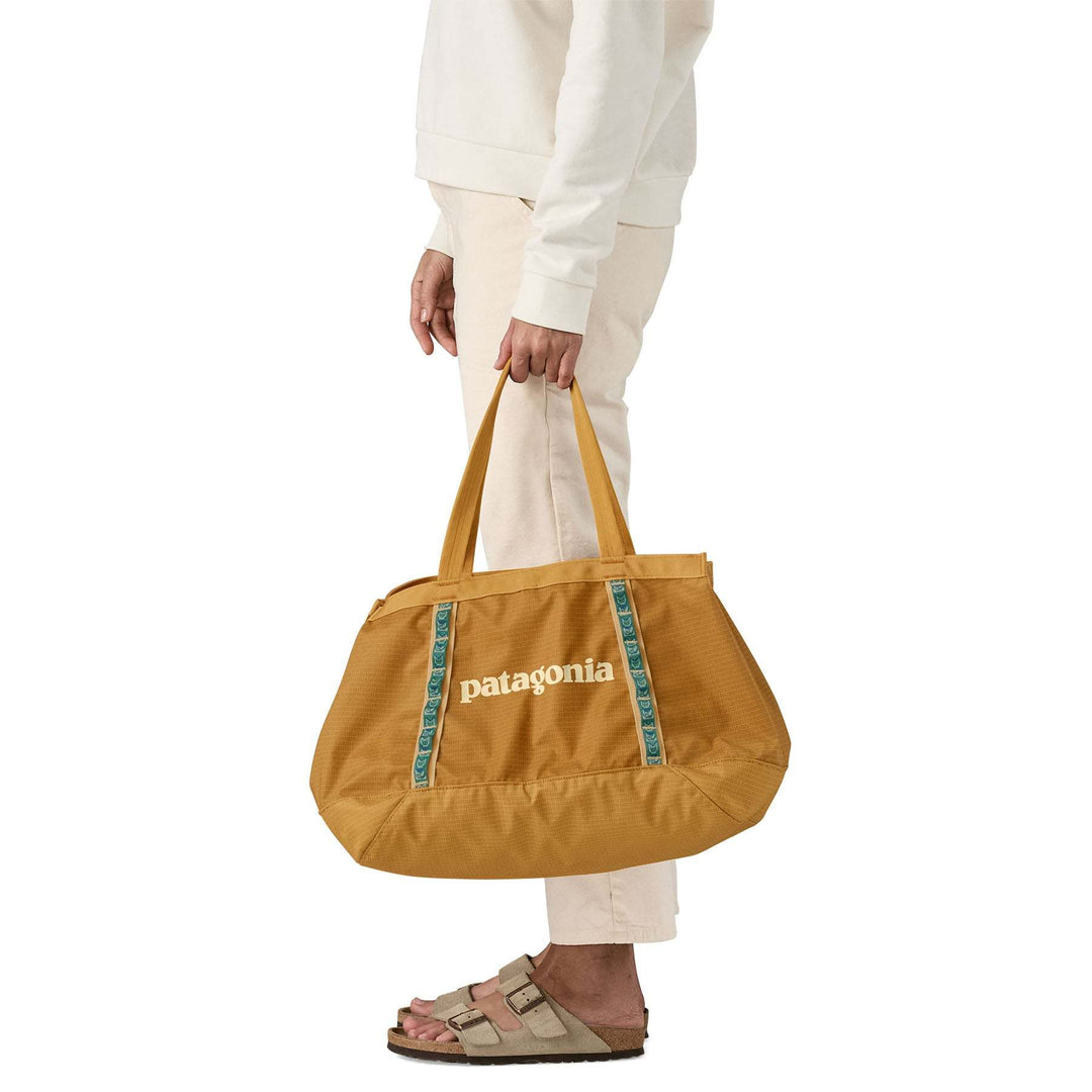 25L Black Hole Tote bag being carried, made from recycled materials, Fair Trade Certified.