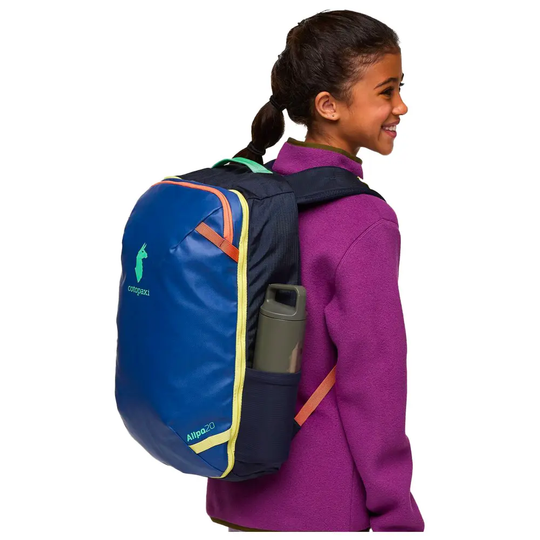 Allpa Mini 20L travel pack on a child, featuring durable blue material, chest clip, and side bottle pocket.