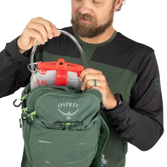 Raptor 10 hydration backpack with 2.5L Osprey Hydraulics reservoir being filled, green design.