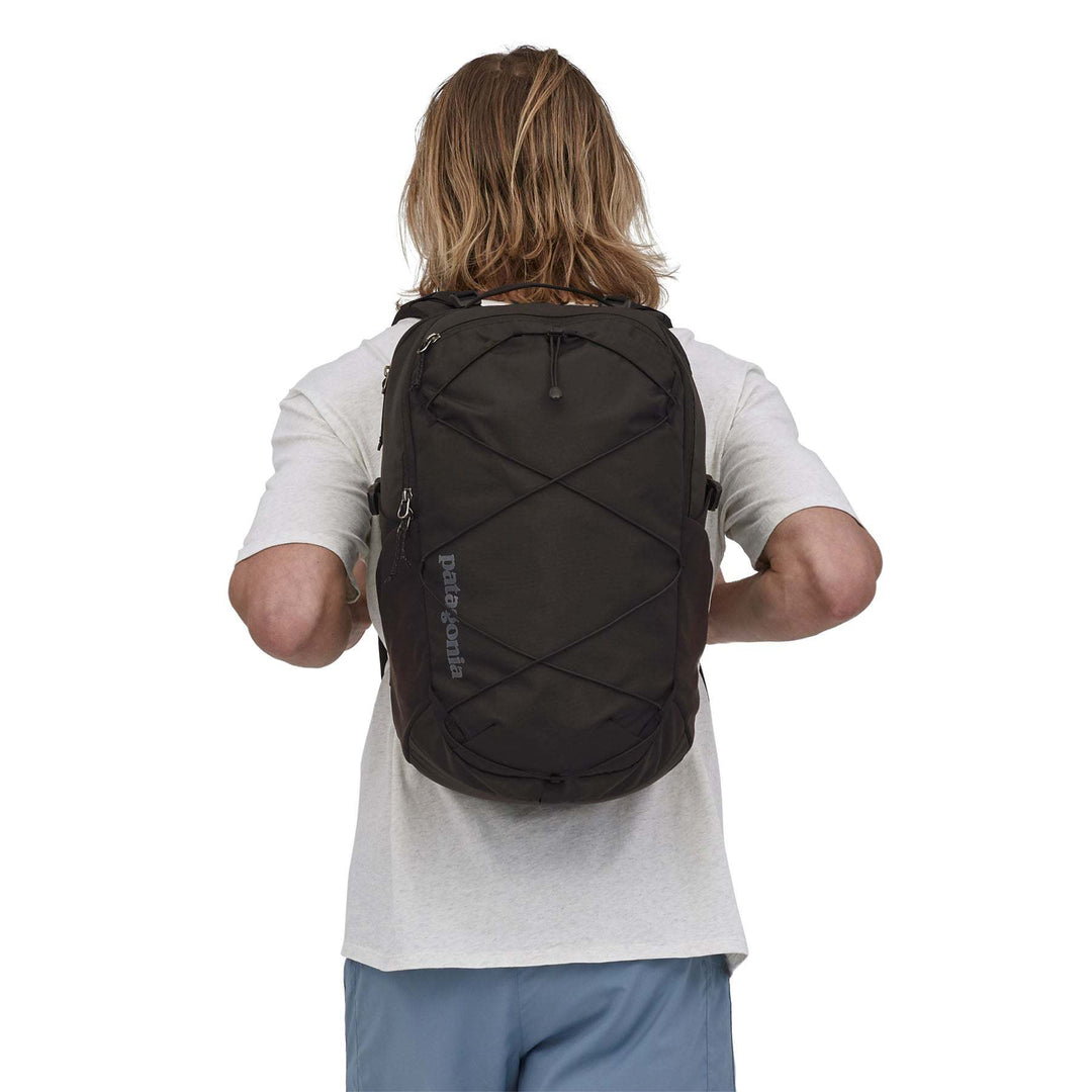 Refugio Day Pack 30L backpack for daily use, shown on person from behind, featuring recycled polyester material and laptop sleeve.