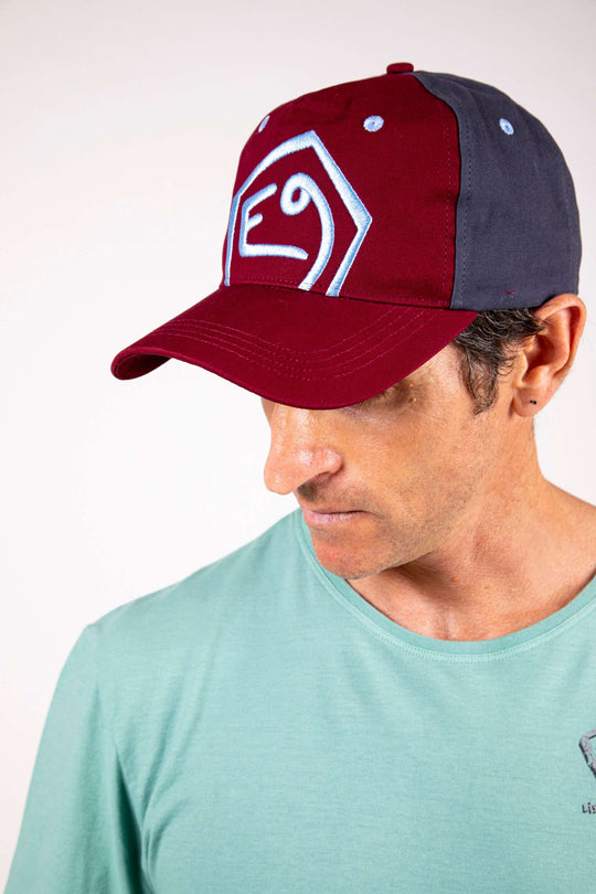 Cappello con visiera bordeaux e blu con ricamo in rilievo, chiusura regolabile, 100% cotone.