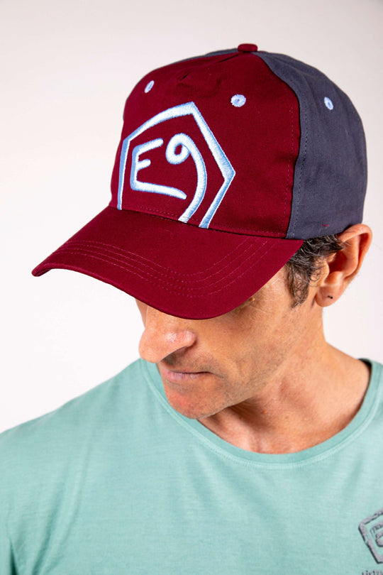 Cappello con visiera marrone e blu con ricamo rialzato, chiusura posteriore regolabile.