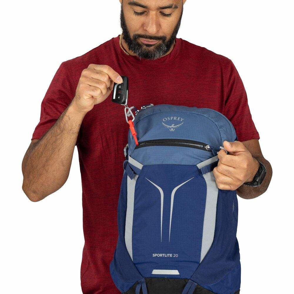 Zaino giornaliero blu in nylon, con pannello frontale elastico, dettagli grigi e cinghie laterali regolabili.