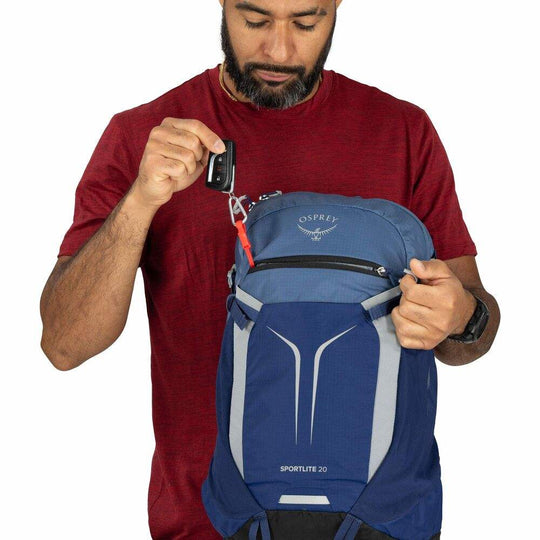 Zaino giornaliero blu in nylon, con pannello frontale elastico, dettagli grigi e cinghie laterali regolabili.