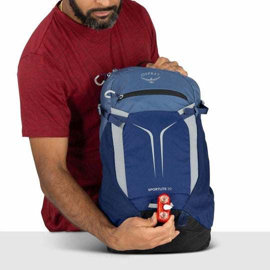 Zaino giornaliero Sportlite 20 blu in nylon riciclato, con inserti grigi, tasca frontale elasticizzata e dettagli riflettenti.