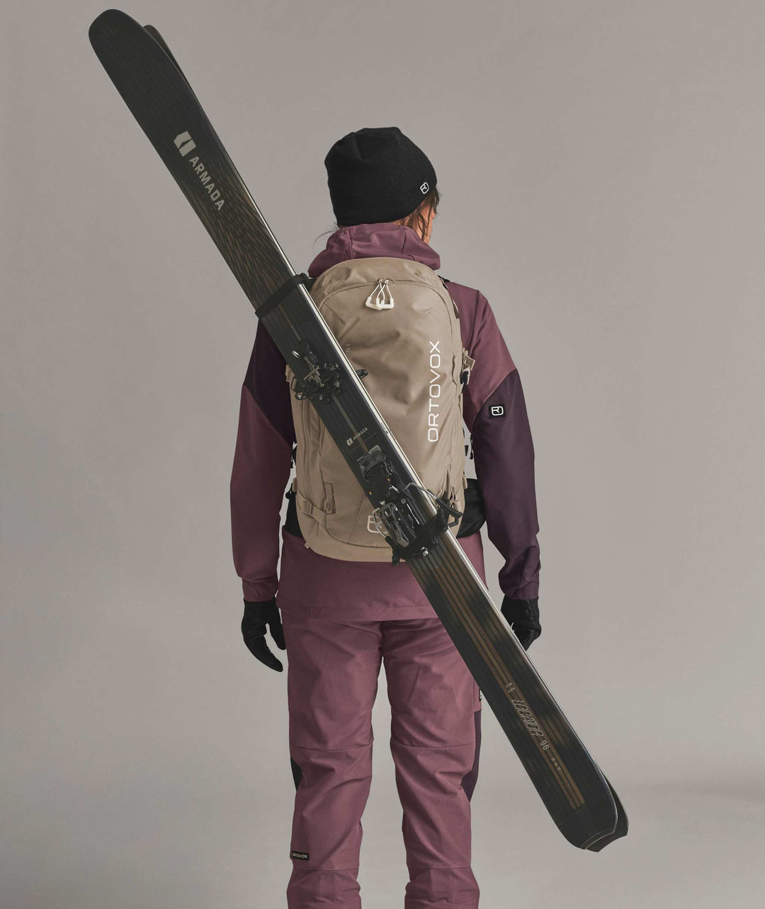 Ortovox Venet Tour 28 S Dark Linen, indossato con sci fissati in diagonale