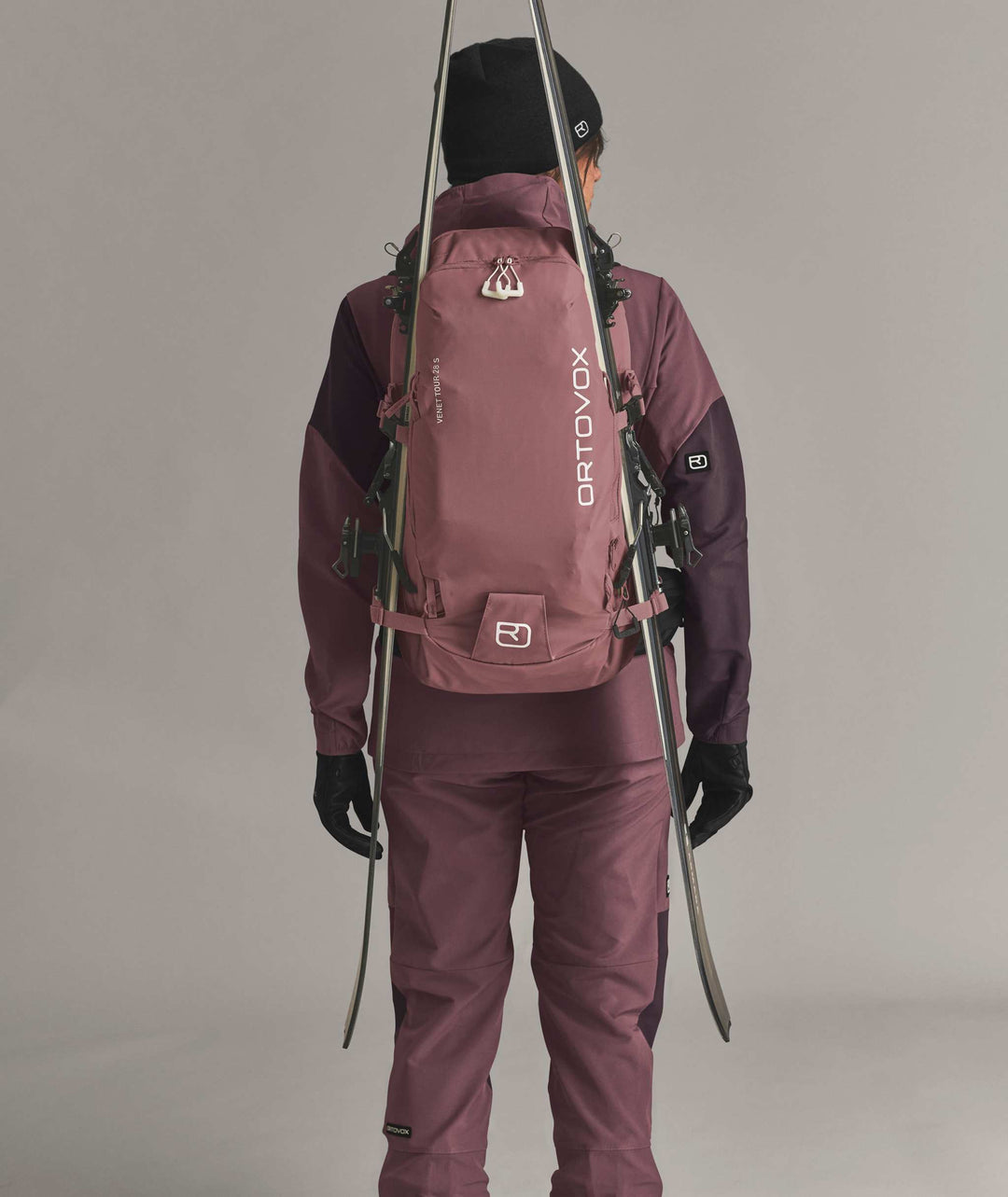 Ortovox Venet Tour 28 S Dusk Rose, indossato con sci fissati lateralmente
