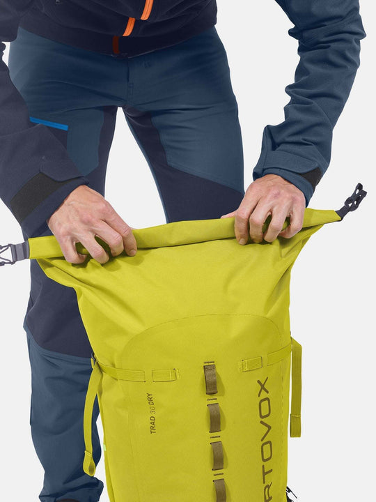 Weather-resistant Trad 30 Dry climbing backpack being rolled shut.