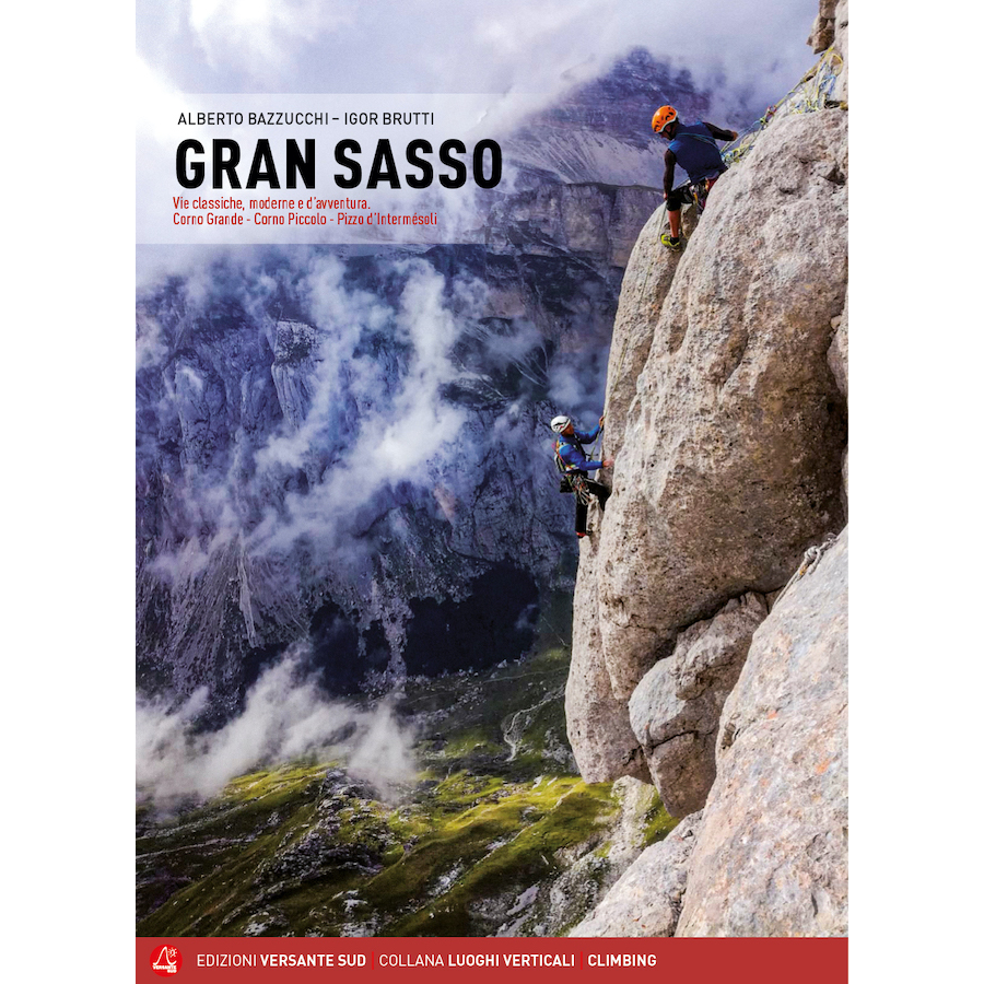 Climbers ascending steep rock face in Gran Sasso mountain with misty valley background